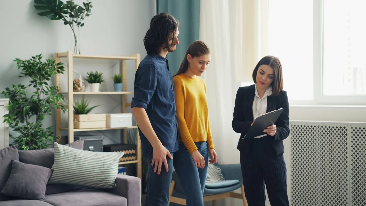 Corretor conversando com cliente em uma sala de estar